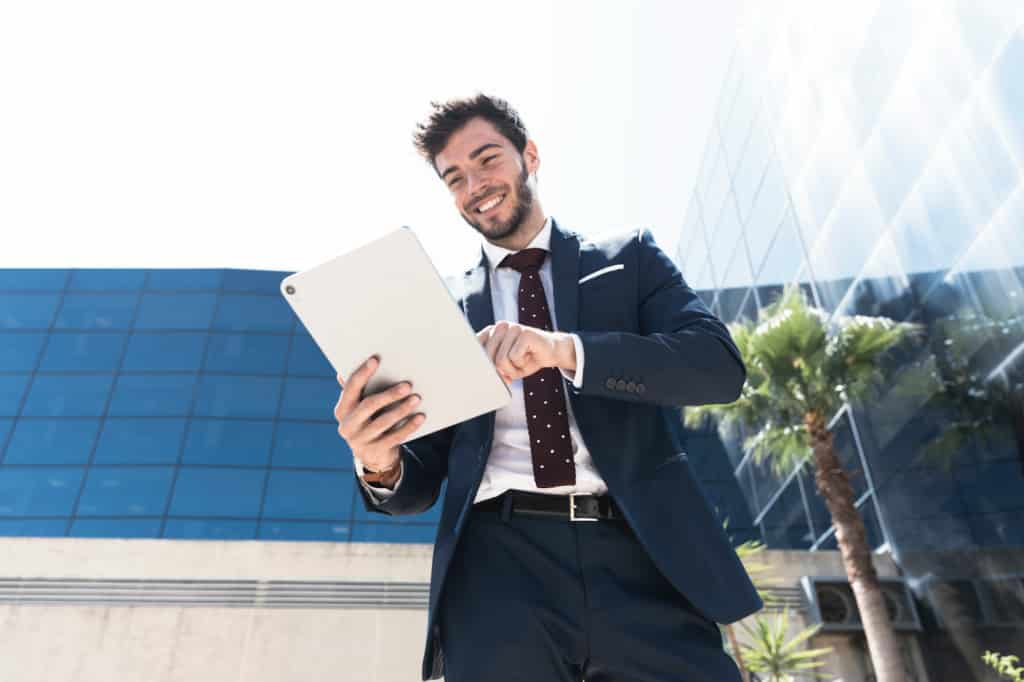 A man holding a tablet against the background of a building