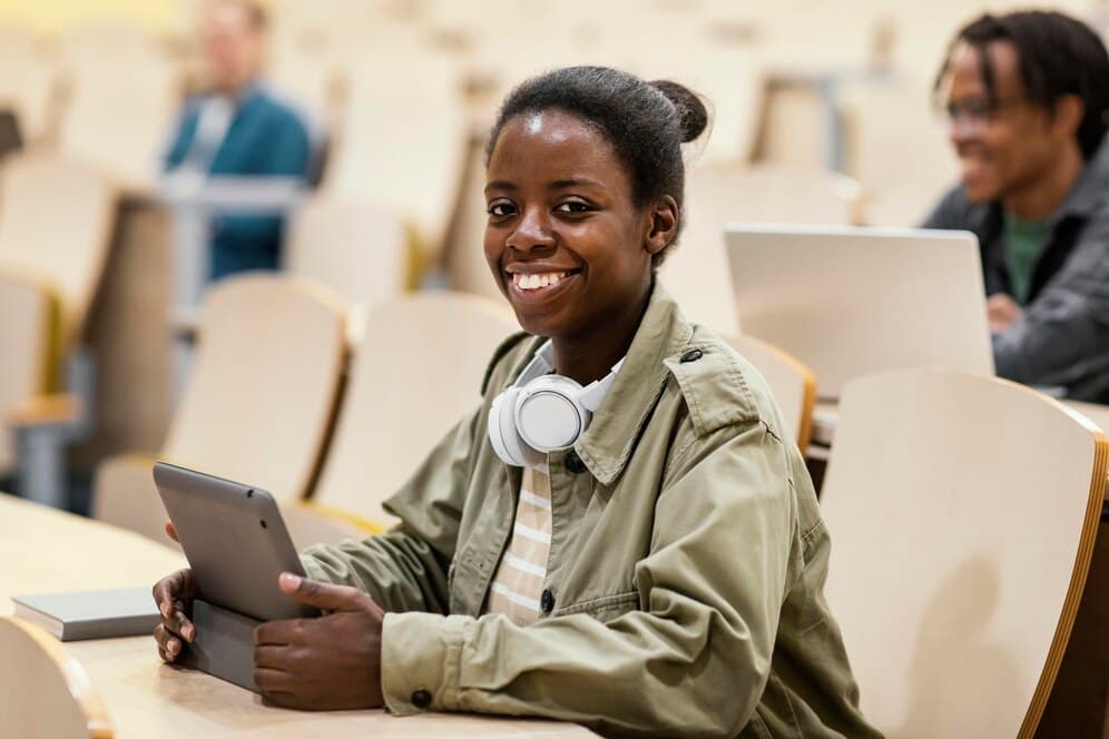 A young woman using a tablet in a university lecture hall