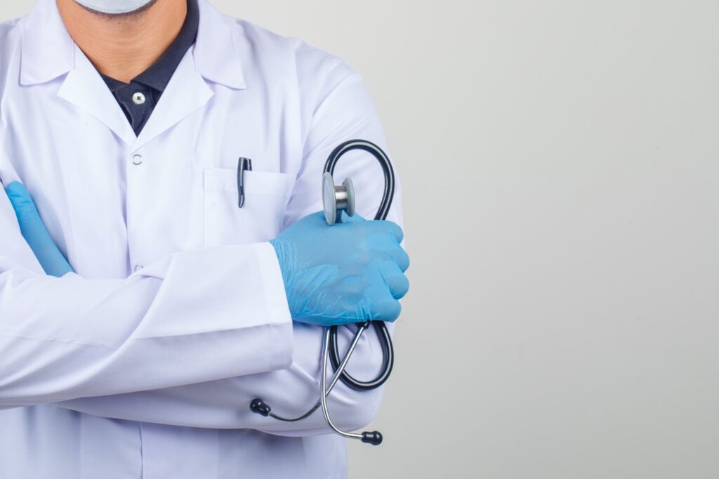 Doctor crossing arms while holding stethoscope in white coat
